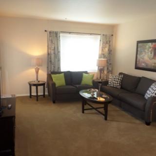 A cozy living room with a comfortable couch, coffee table, and warm lighting.