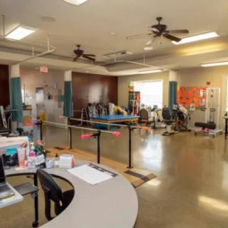 A spacious physical therapy room equipped with various rehabilitation and exercise equipment.