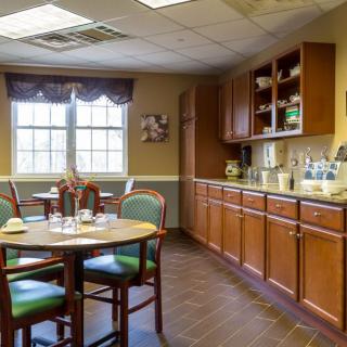 A cozy kitchen and dining area with wooden cabinets, a table, and chairs.