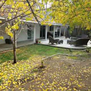 A serene backyard scene showcasing a patio surrounded by autumn leaves.