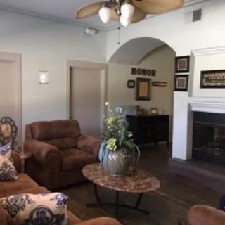 A cozy living room with plush sofas, a central coffee table, and a fireplace adorned with decor.