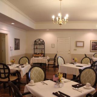 A quiet and elegantly decorated dining room featuring neatly arranged tables and chairs.
