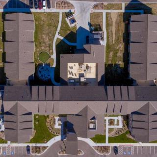 Aerial view of a residential complex with symmetrical building arrangement and landscaped areas.