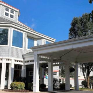 A modern building with a large porch under a clear blue sky.