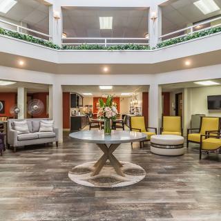 A modern lobby interior with stylish seating and a central table adorned with flowers.