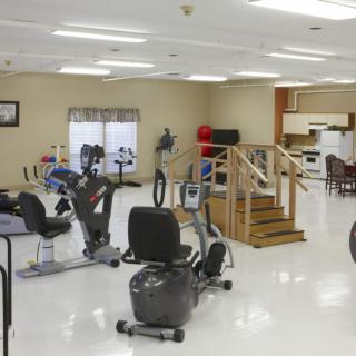 A well-equipped rehabilitation room with various exercise machines and therapy tools for physical therapy.