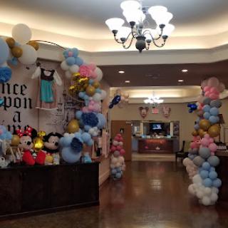 A festive entrance decorated with colorful balloons and Disney characters for a children's celebration.