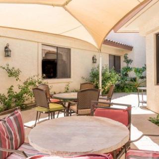 A sunny patio with comfortable seating and shade.