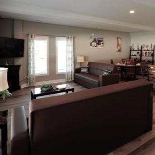A cozy living room with sofas, a coffee table, and a television, plemented by a dining area.