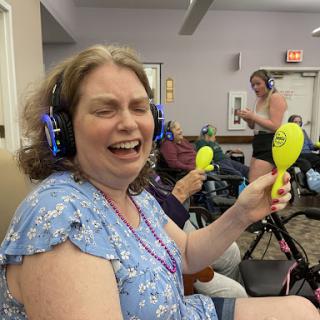 Participants enjoying a lively music session with headphones and maracas.
