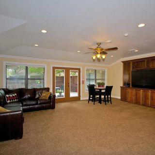 Spacious living room with a couch, table, ceiling fan, and large windows.