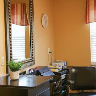 A cozy home office space featuring a mirror, a decorative plant, and warm orange walls.