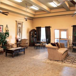 A spacious and elegantly decorated living room with comfortable seating and large windows.