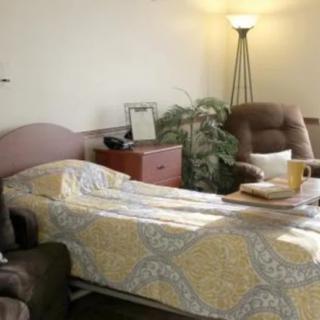 A quiet hospital room with a bed, chairs, and soft lighting.
