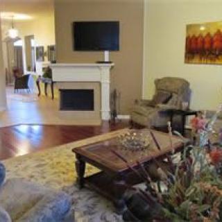 A cozy living room featuring a fireplace, wall-mounted television, and comfortable seating with artistic decor.