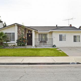 A single-story suburban house with a well-maintained lawn and driveway.