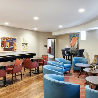 A modern lounge with comfortable seating and colorful artwork on the walls.
