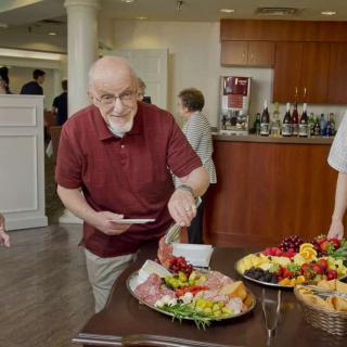 A man serving himself from a buffet table at a social gathering.