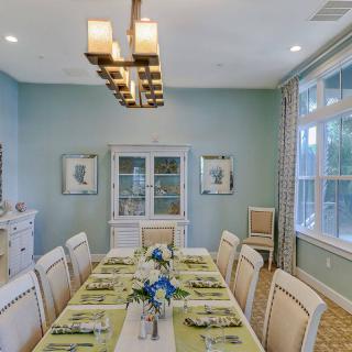 A beautifully arranged dining room with an elegant table setting and a modern chandelier.