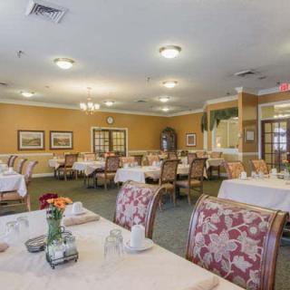 A spacious dining room with elegantly set tables and floral decorations.
