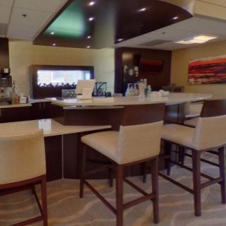A modern bar area with high chairs and stylish interior design.