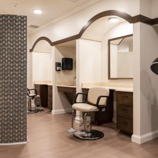 A modern hair salon interior with styling stations and mirrors.