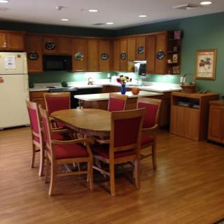 A cozy kitchen and dining area with wooden cabinets and a dining table surrounded by chairs.