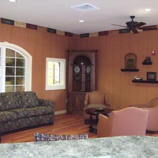 A cozy living room with a patterned sofa, chairs, and wooden decor.