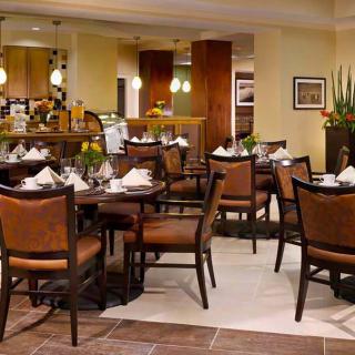 An elegantly set dining area in a restaurant with neatly arranged tables and chairs.