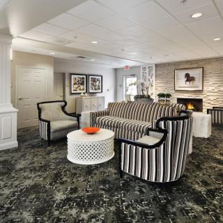 A modern lobby featuring a stylish seating area with striped furniture and a cozy fireplace.