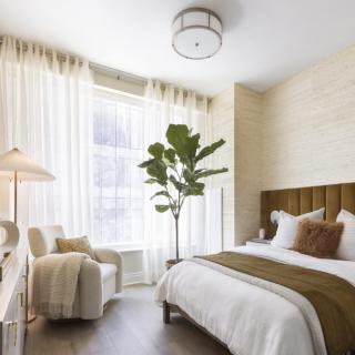 A modern, cozy bedroom with soft colors and ample natural light.