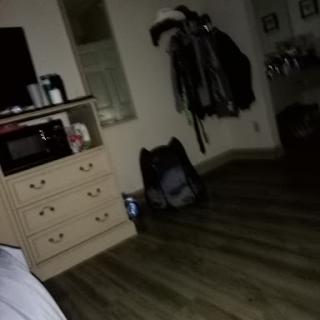 A glimpse of a cozy interior space featuring a dresser and some clothing.