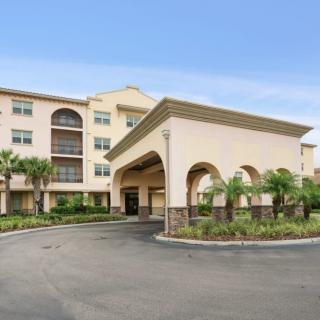 A hotel building with a grand entrance and palm trees in the foreground.