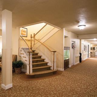 A warmly lit hallway with a carpeted staircase and decorative elements.