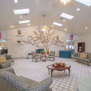 A welcoming lobby with plush seating and a decorative wall feature under skylights.
