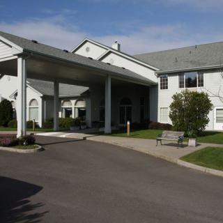 A large building with a covered entrance and landscaped surroundings.