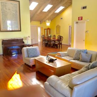 A spacious living room with a cozy seating area, hardwood floors, and an adjacent dining area.
