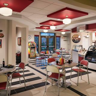 A retro-themed diner with vintage decor and classic red and white furniture.