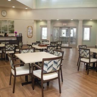 A modern dining area with neatly arranged tables and chairs, featuring a bright and spacious interior.