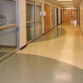 A clean and bright hospital hallway with doors on both sides.