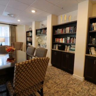 A cozy library space with bookshelves, a table, and chairs for reading.