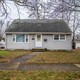 A small suburban house with a front yard and sidewalk.