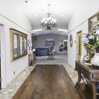 A well-decorated hallway with a chandelier, wooden floor, and elegant furnishings.