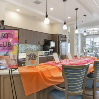 An inviting art club setup with vibrant tablecloths in a modern kitchen area.