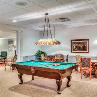 A cozy game room featuring a billiard table and comfortable seating.