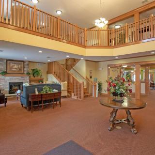A spacious lobby with a staircase, seating area, and elegant decor.