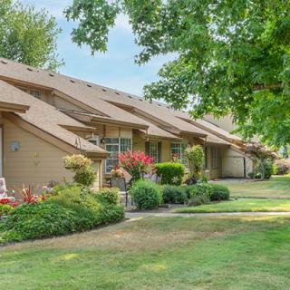 A picturesque residential neighborhood with neatly landscaped lawns and trees.
