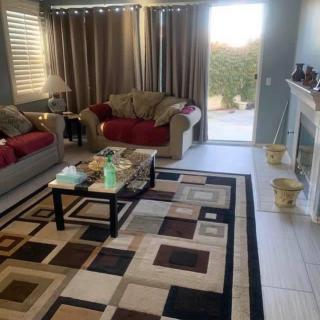 A cozy living room with sofas, a coffee table, and a geometric rug.
