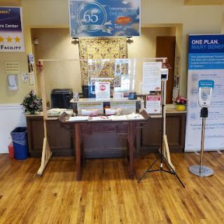 A reception area featuring an information desk, signage, and protective barriers.