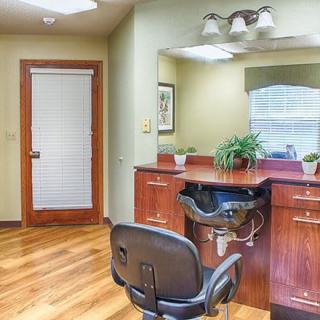 A cozy hair salon interior with a styling station, mirror, and plants.
